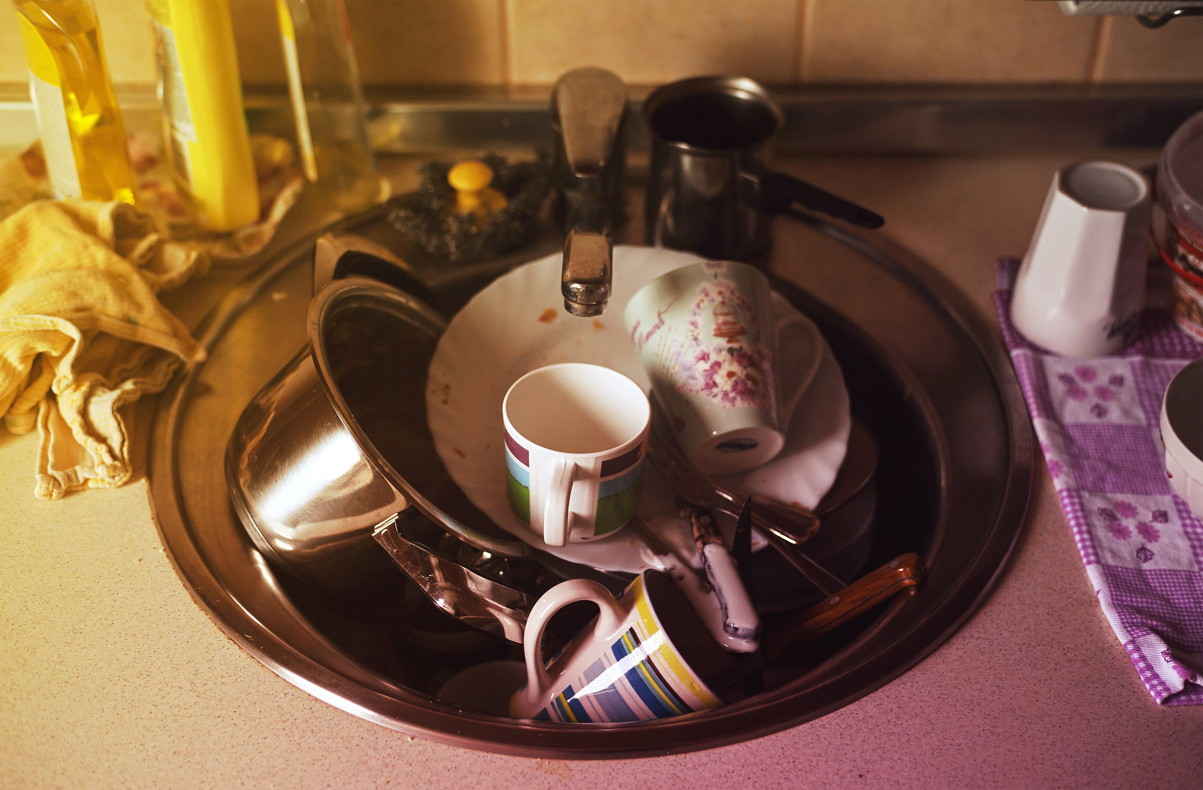 A guest kitchen sink full of dirty dishes, the kind of cleanup Airbnb hosts used to demand before checkout