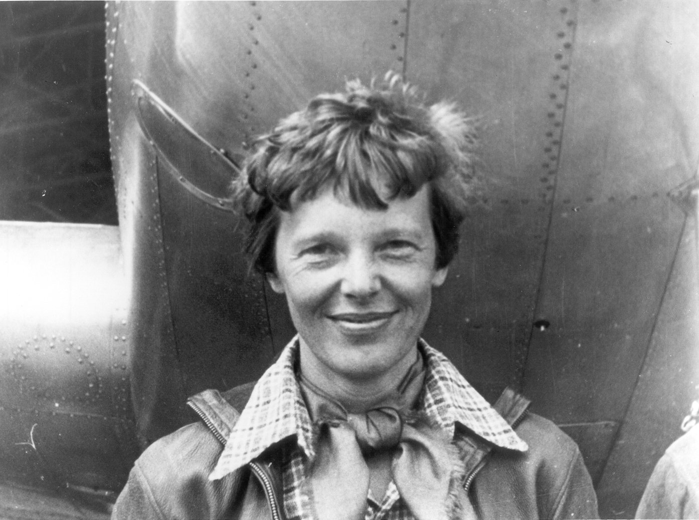 Amelia Earhart standing under the nose of her Lockheed Electra, 1937