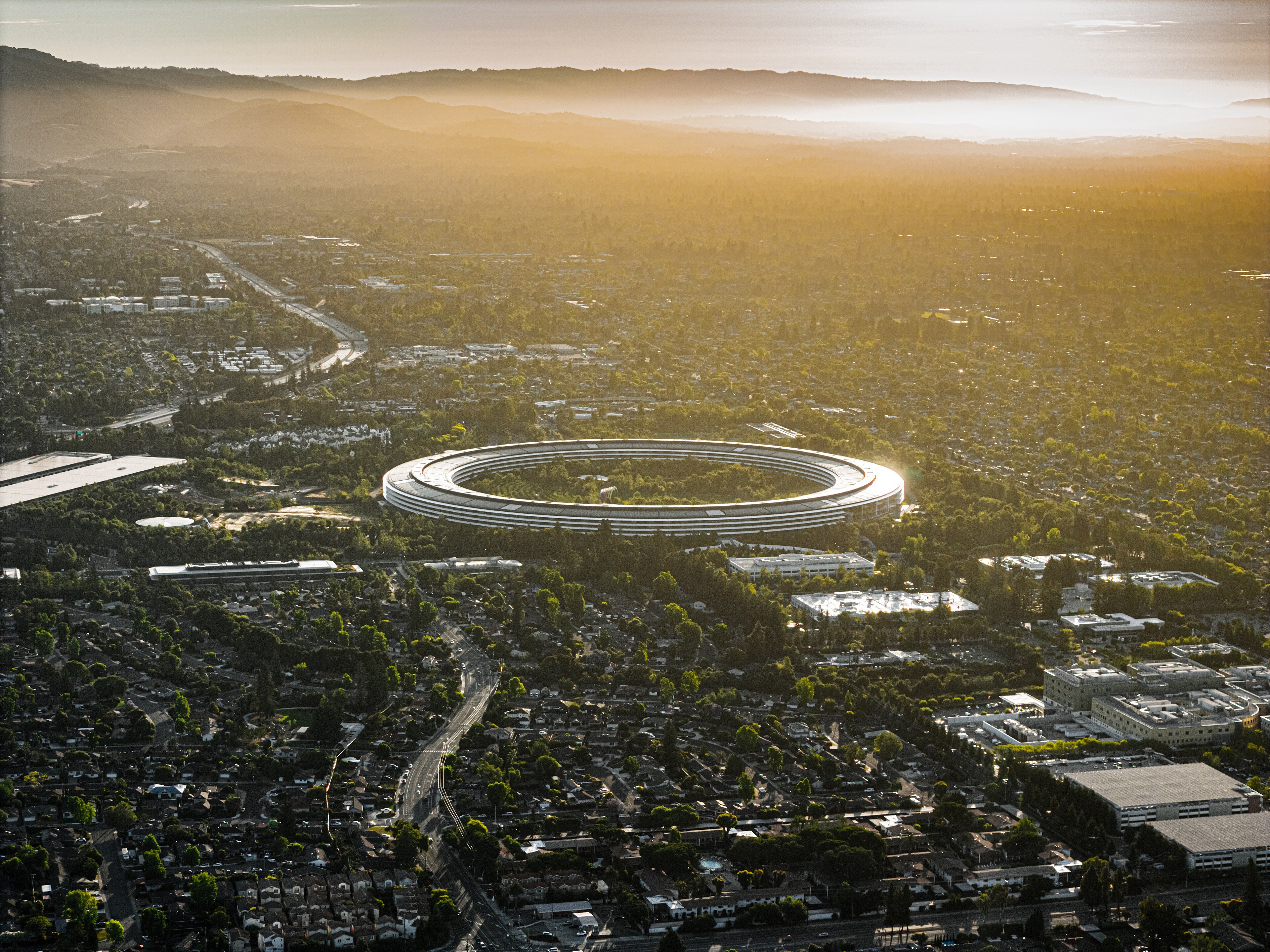 Apple Park, the ring-shaped Apple headquarters in Cupertino, California, seen from the air at sunset