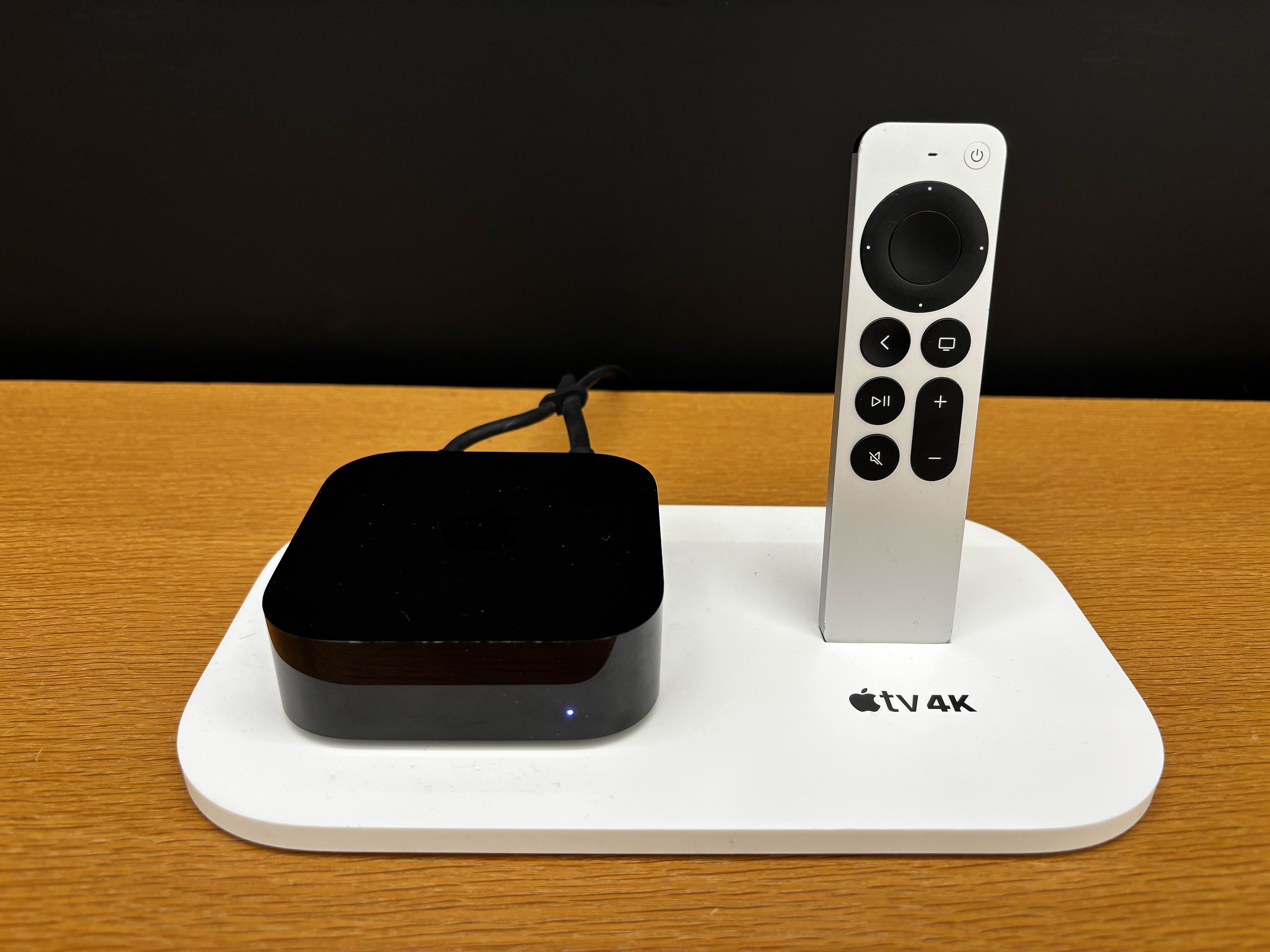 An Apple TV 4K box sitting next to its Siri Remote