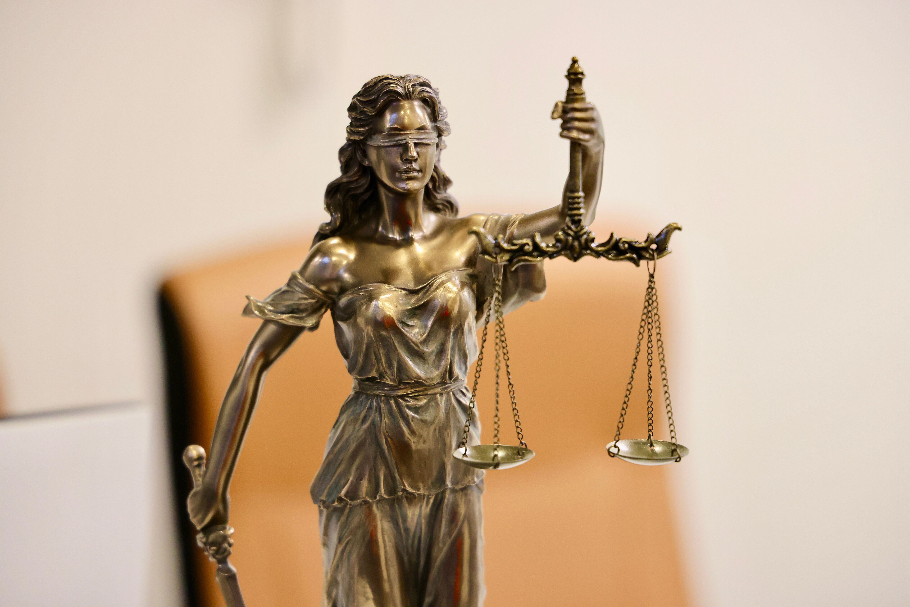 A close-up of a Lady Justice statue holding a set of scales