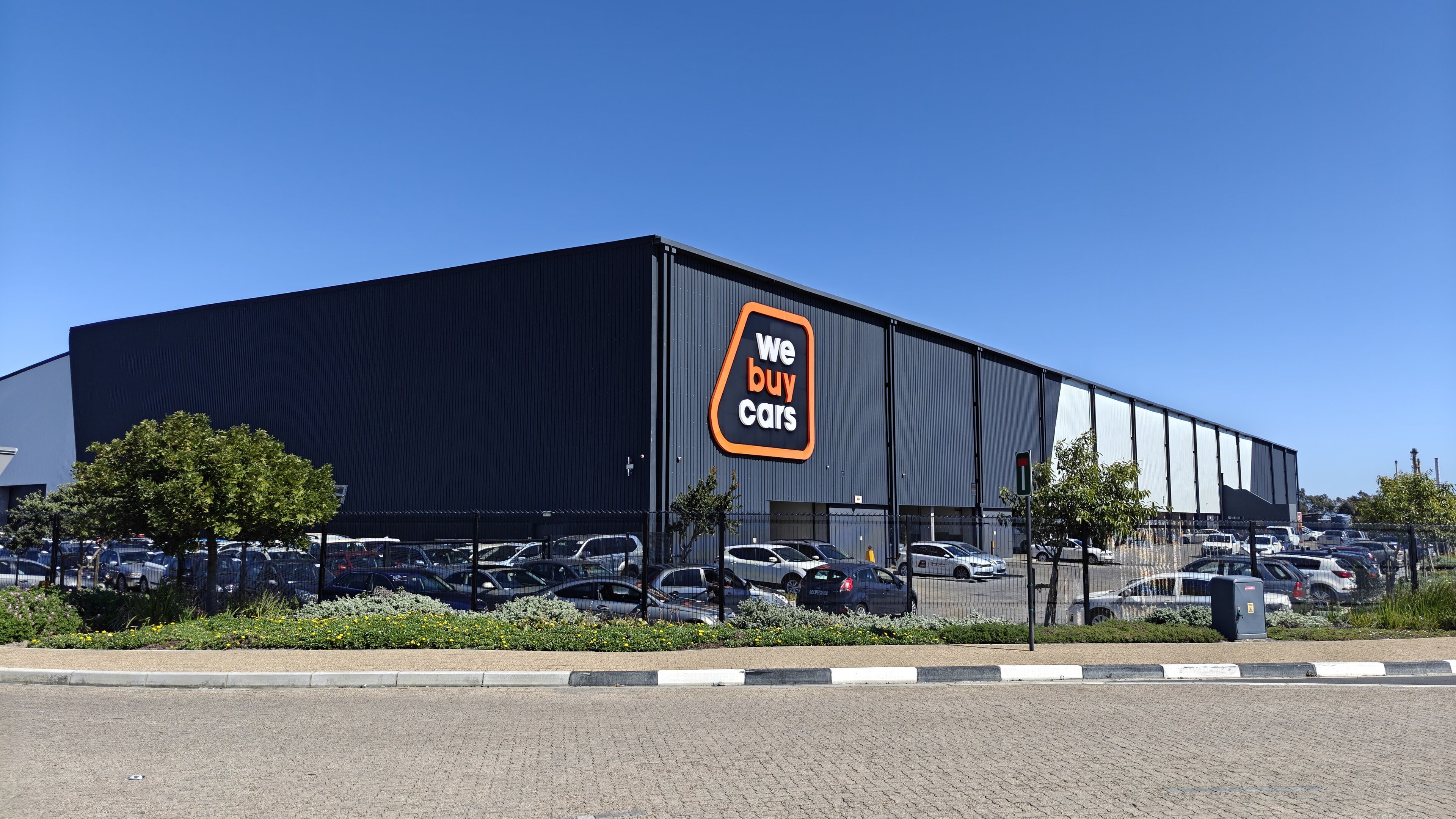 The WeBuyCars warehouse and showroom in Montague Gardens, Cape Town, with rows of used cars outside