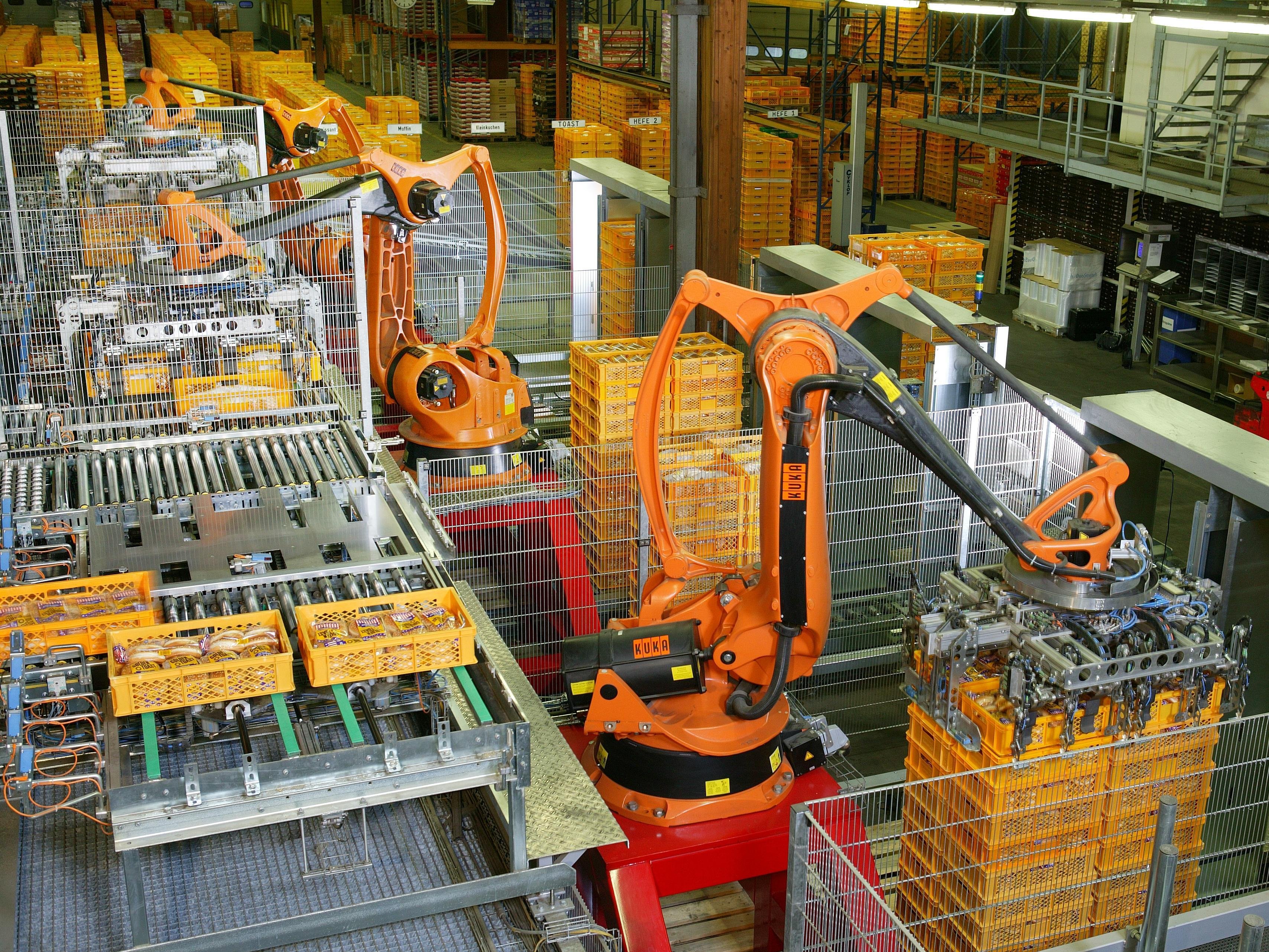 An industrial robot arm does work a person used to do, the kind of job Gates wants taxed