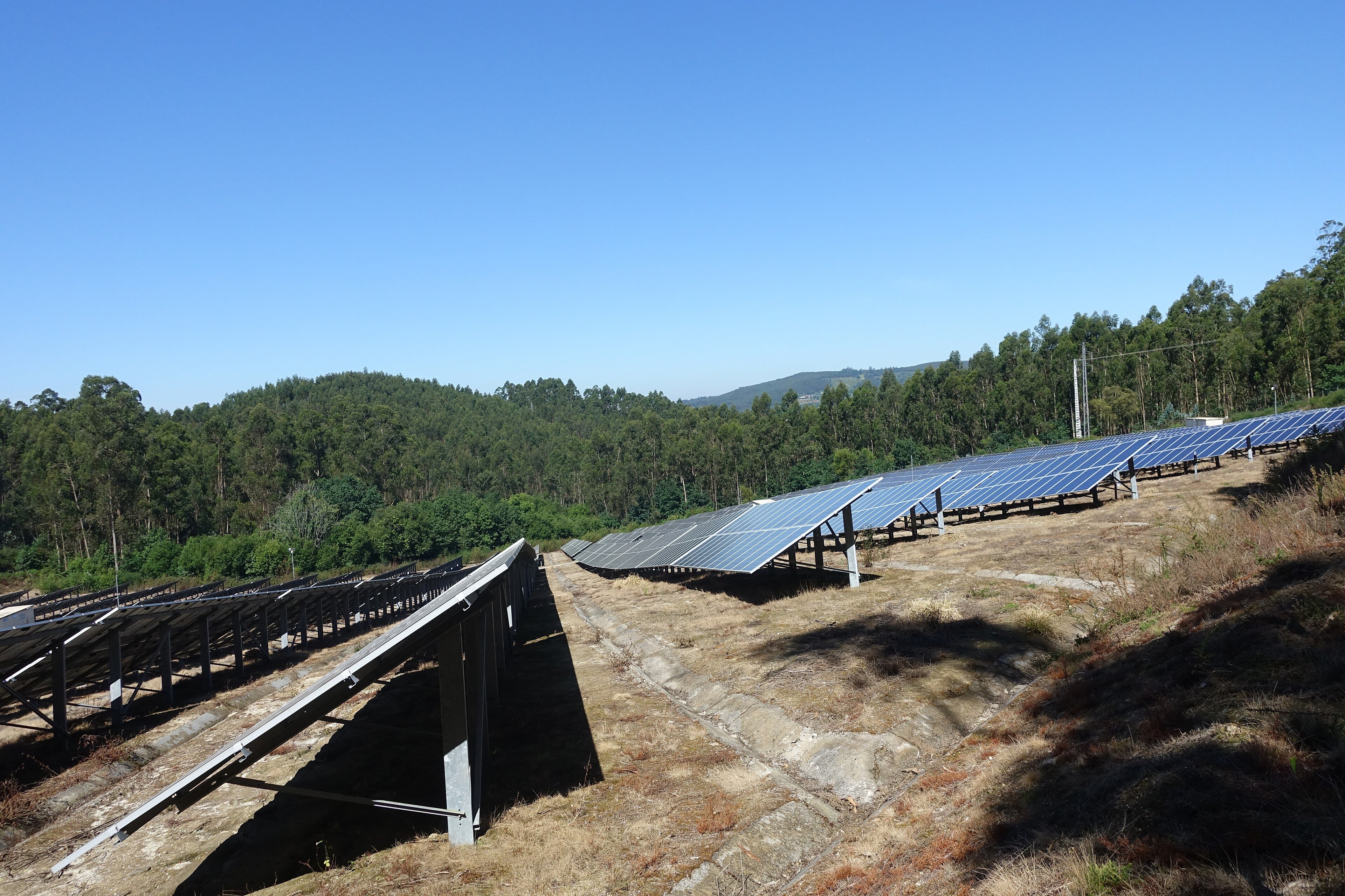 Long rows of solar panels at a photovoltaic power station under a clear sky