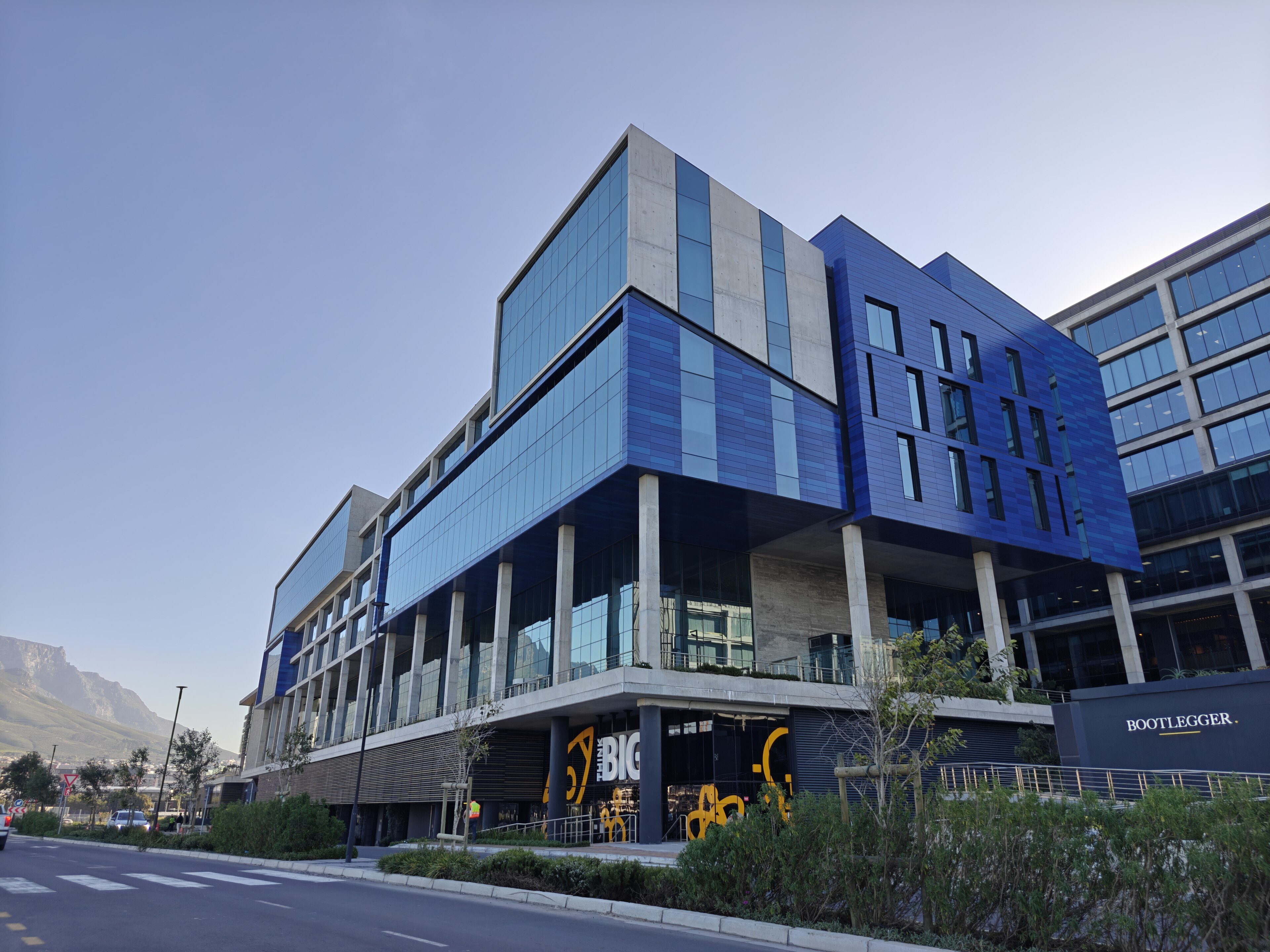 Amazon's new Africa headquarters building in Cape Town, blue and glass offices with Table Mountain behind