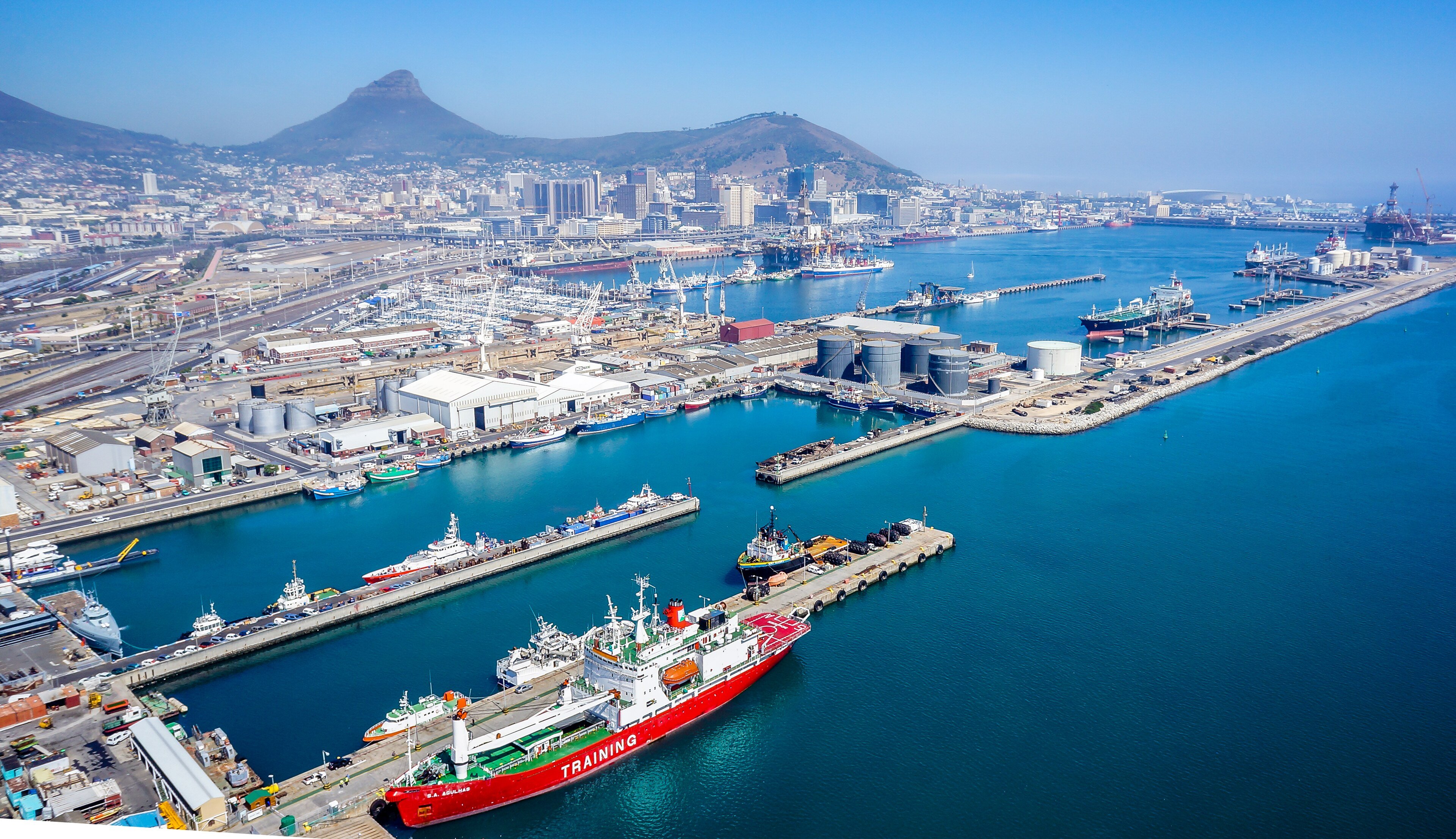 Aerial view of the Port of Cape Town with ships at the quays, the city centre behind and Lion's Head and Signal Hill in the distance