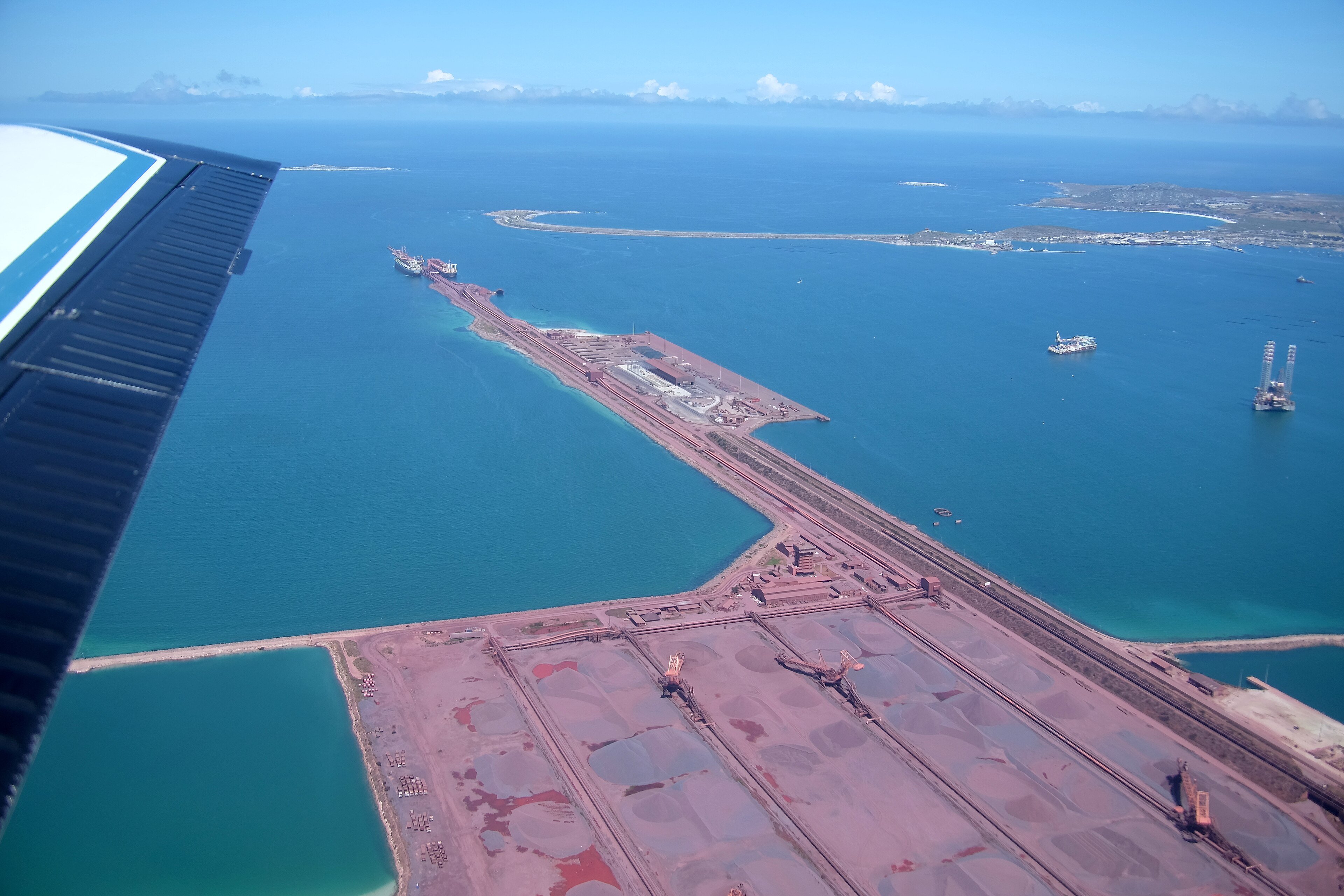 Aerial view of the iron ore stockpiles and long loading jetty at Saldanha Bay, with ships at the berths