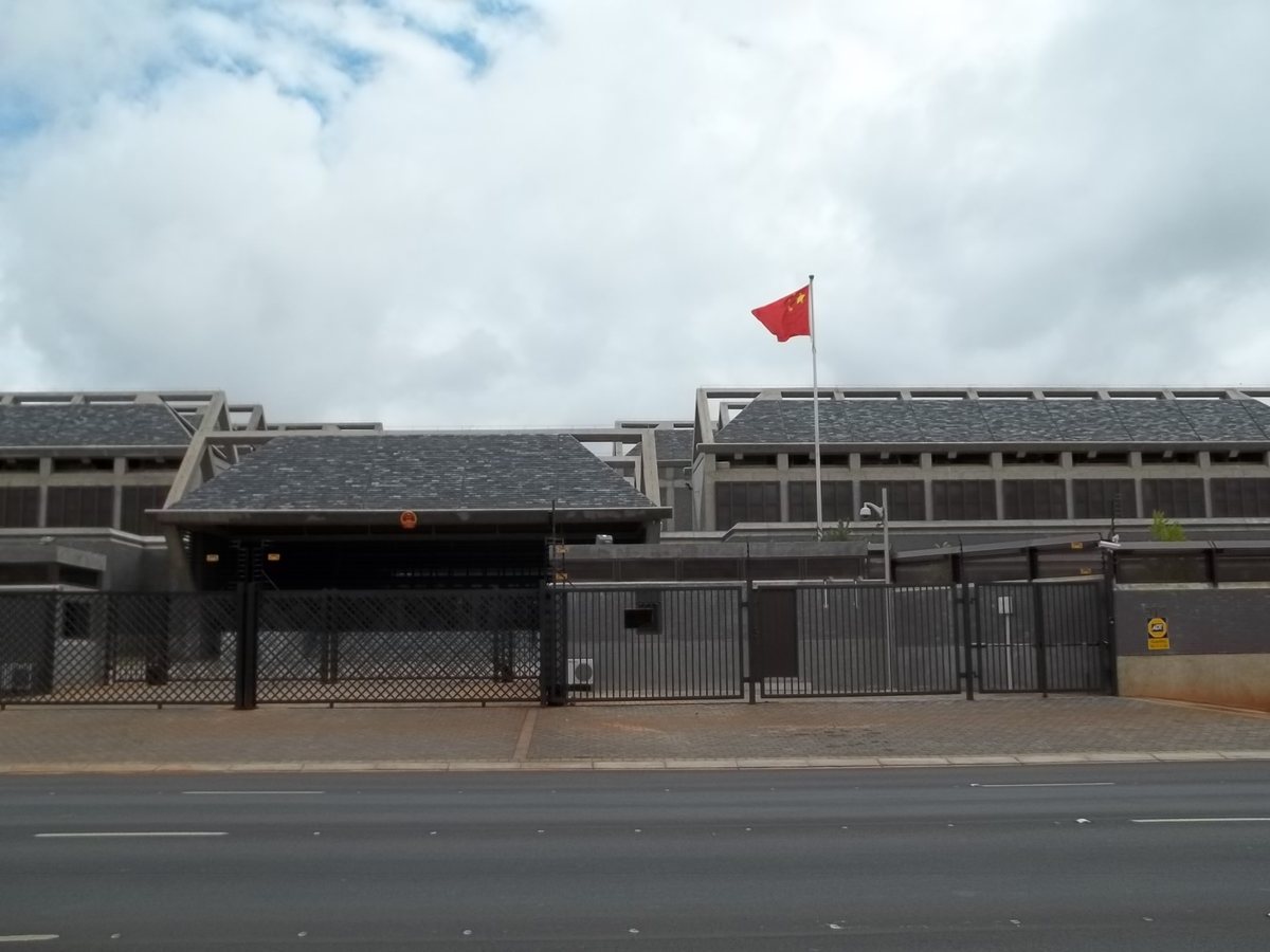Chinese Embassy in Pretoria behind a black fence with the Chinese flag flying