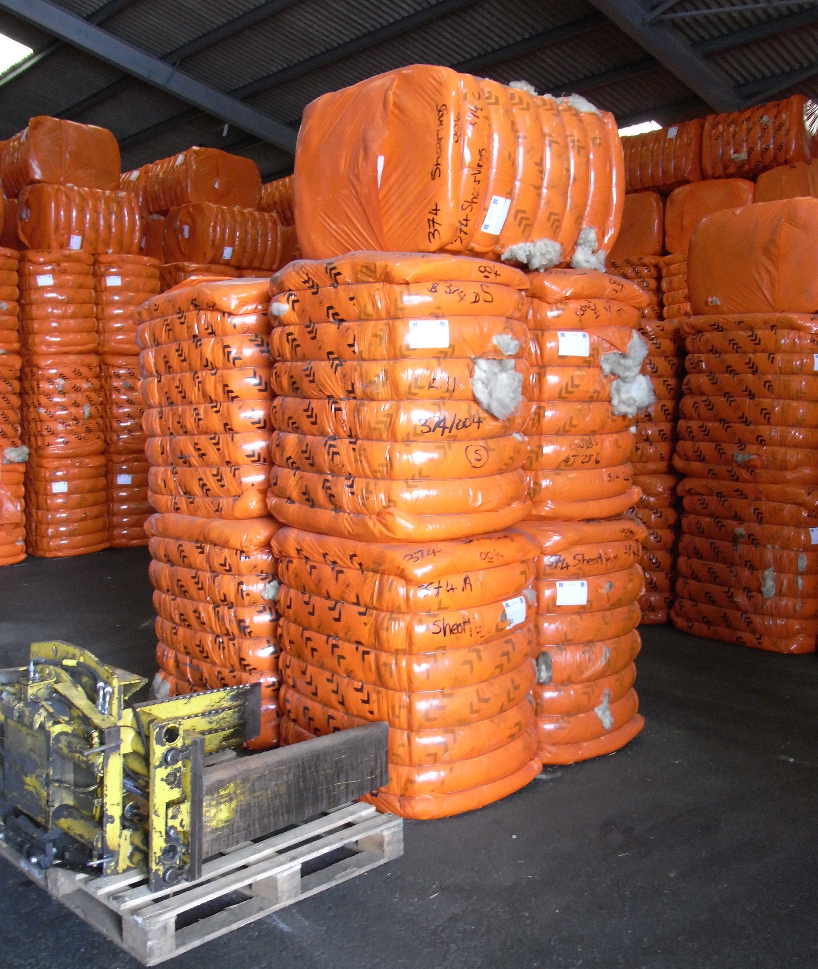 Large bales of graded British wool stacked inside a depot in Devon