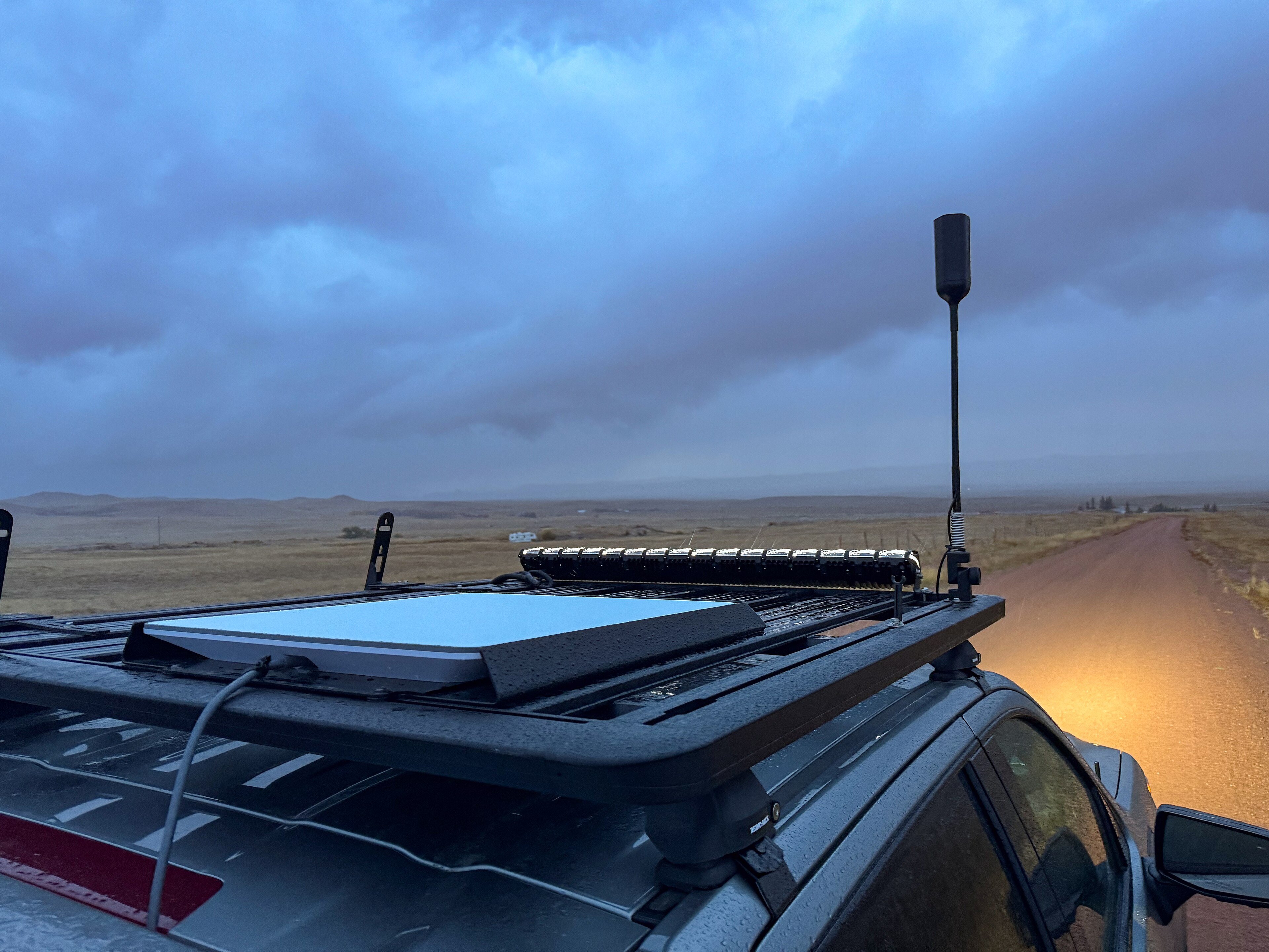 A flat Starlink dish mounted on the roof of a truck