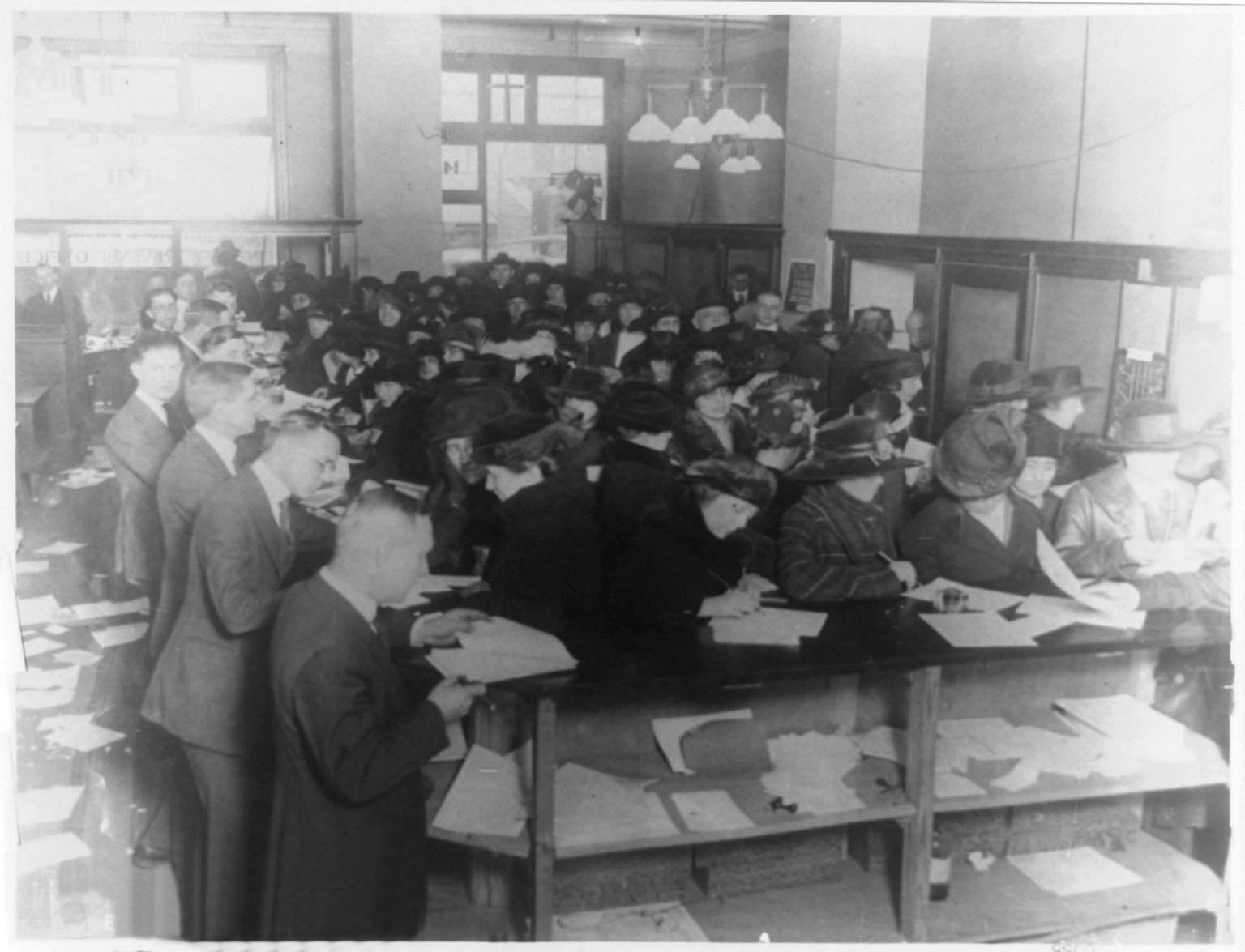 People filling out tax forms in an Internal Revenue office in 1920