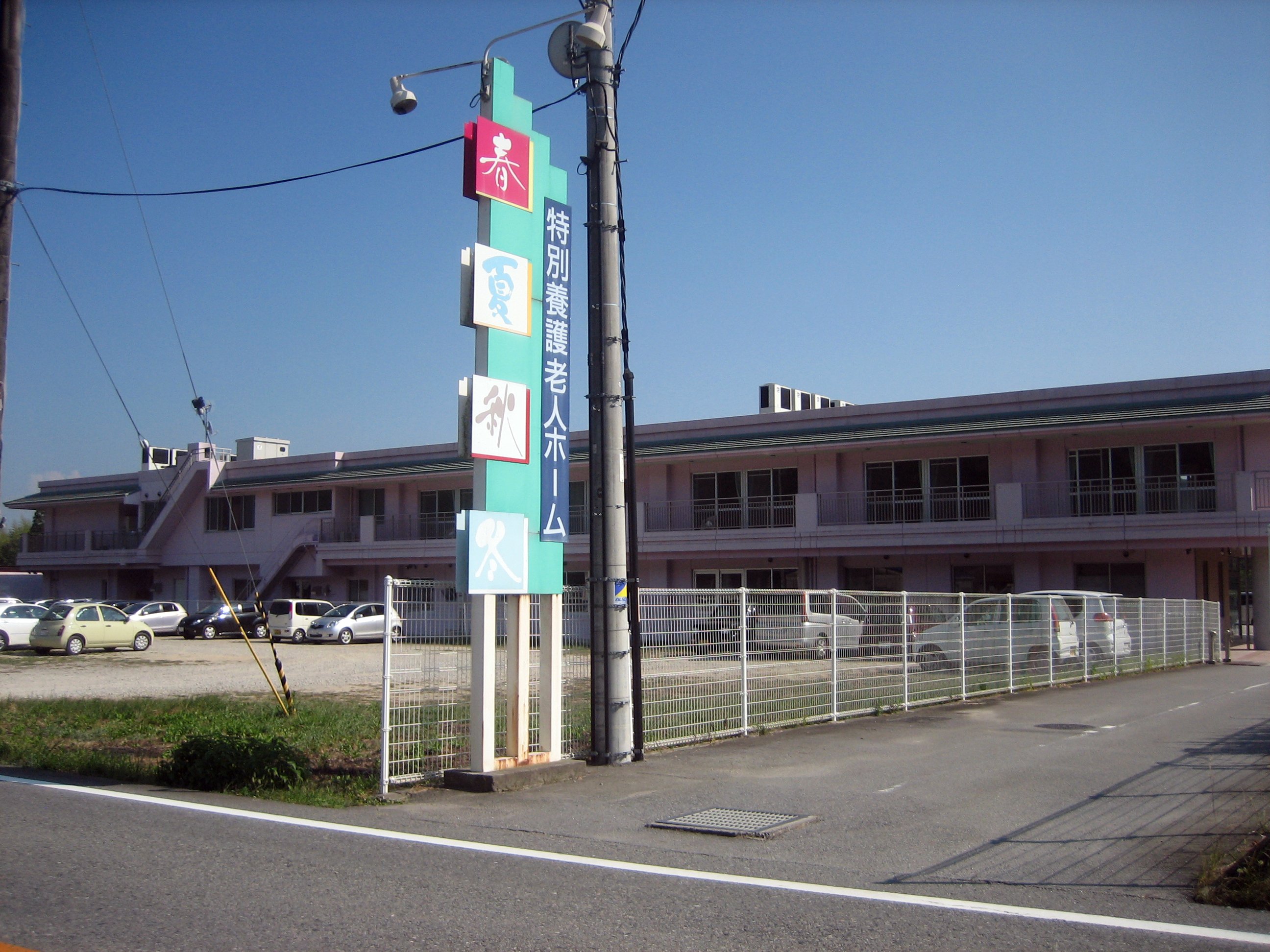 A two-storey special nursing home for elderly people in Japan, with its tall sign showing the four seasons