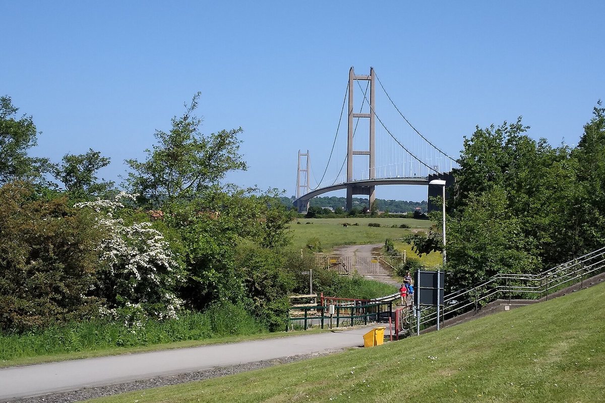 The Humber Bridge near Hull on a sunny day, seen from a green bank with trees