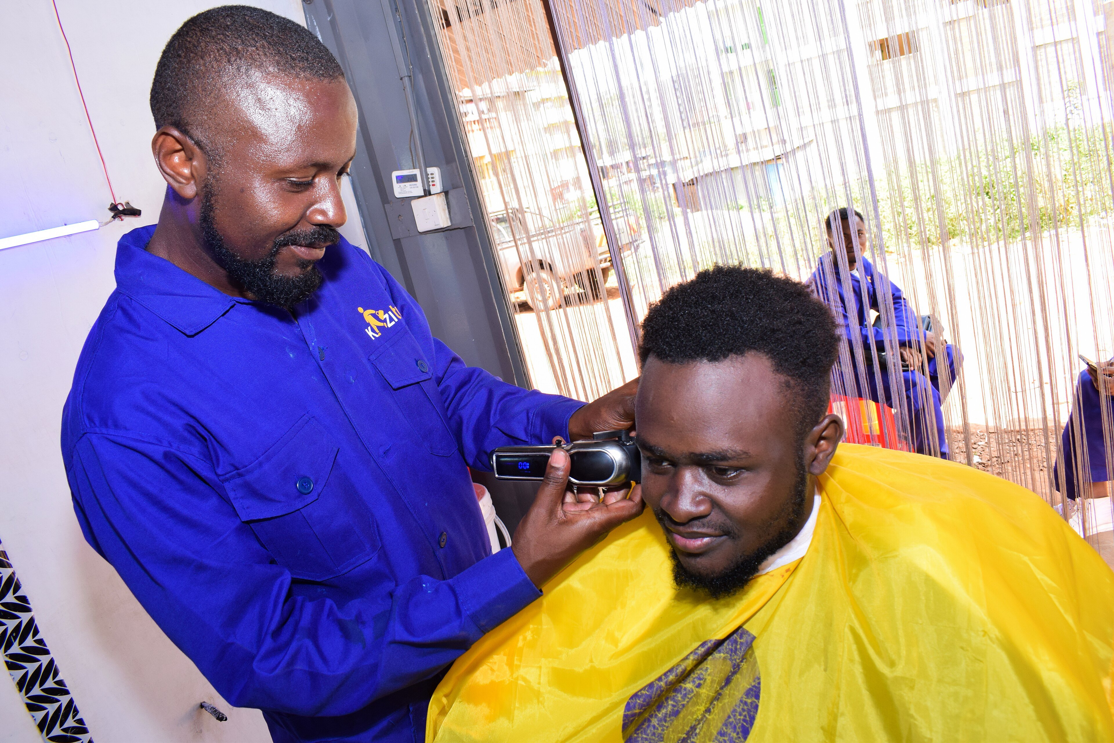 A barber at work with electric clippers