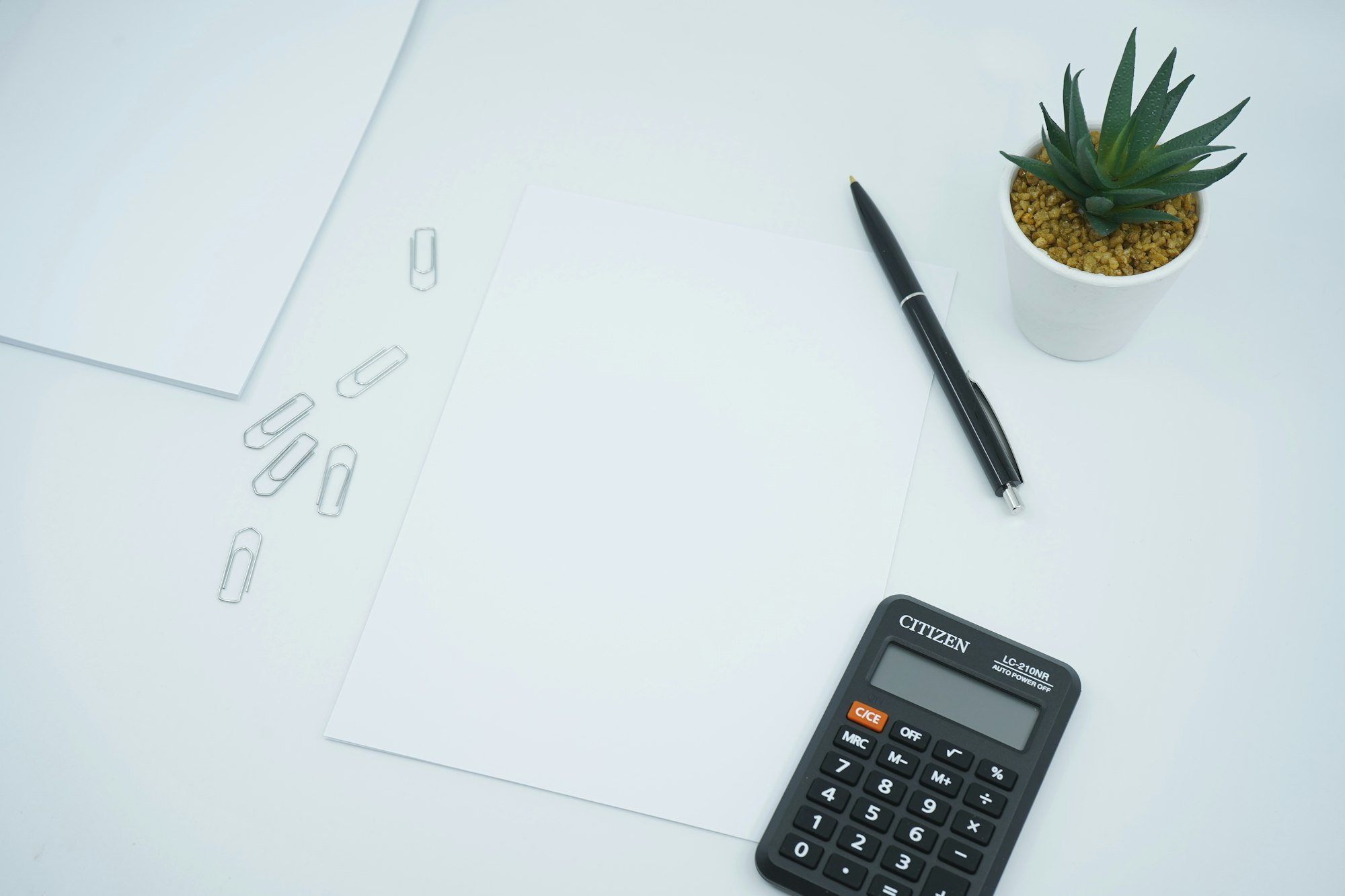 A calculator and pen resting on paper, the kind of math behind a monthly mortgage payment