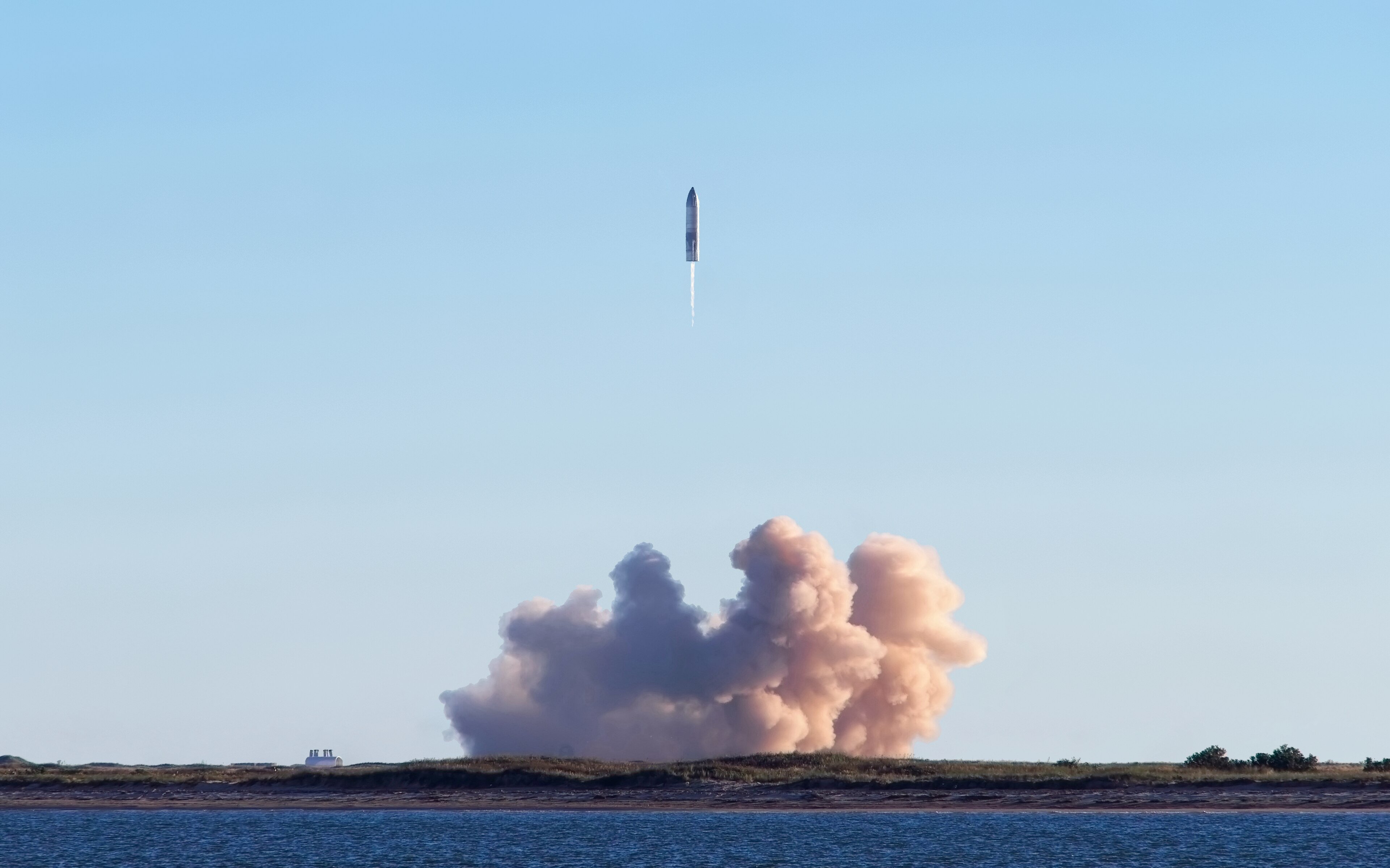 A SpaceX Starship prototype rising on a column of flame over the Texas coast