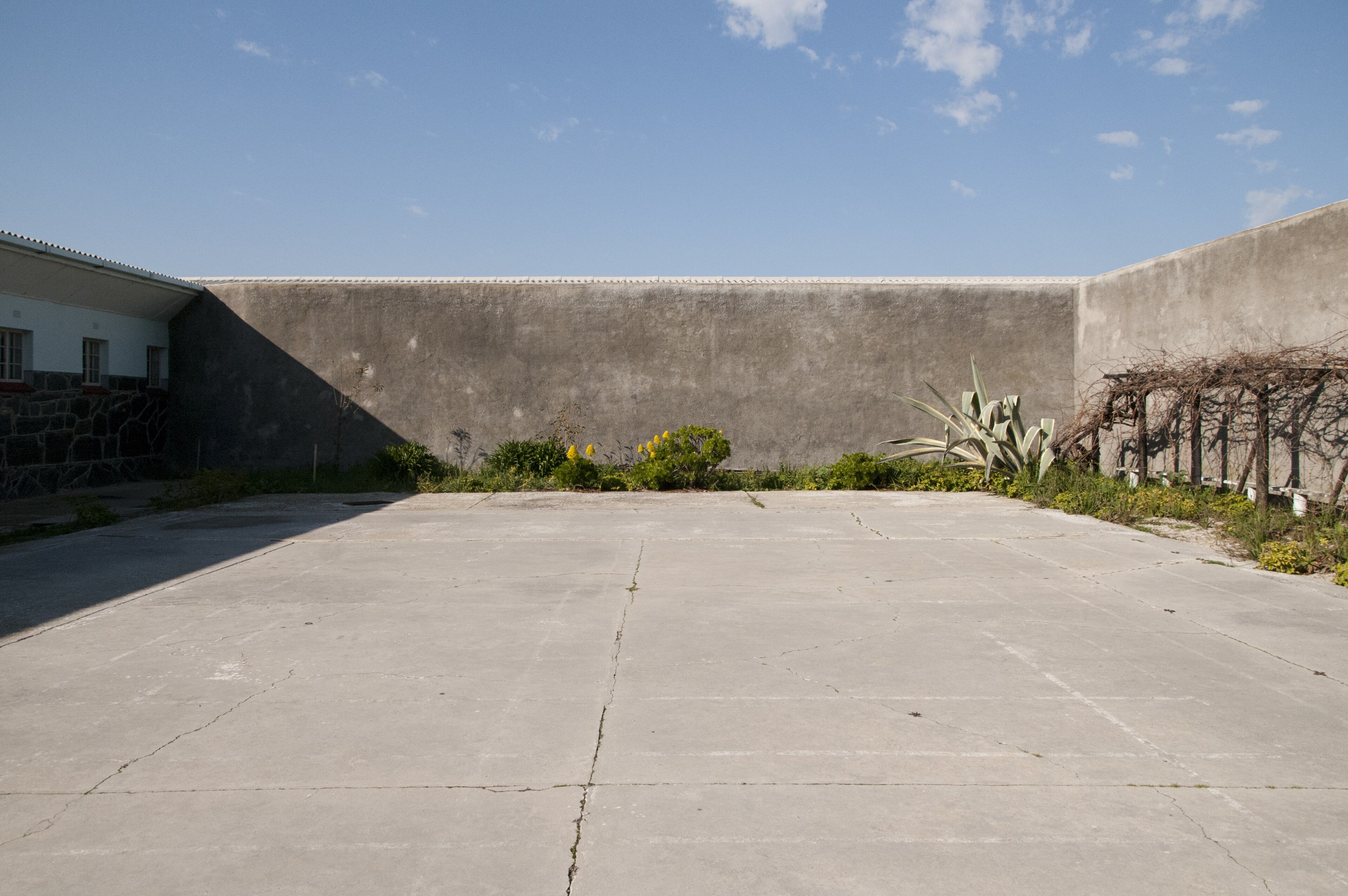 The B-Section courtyard of the Robben Island prison, a bare yard surrounded by stone walls and barred windows