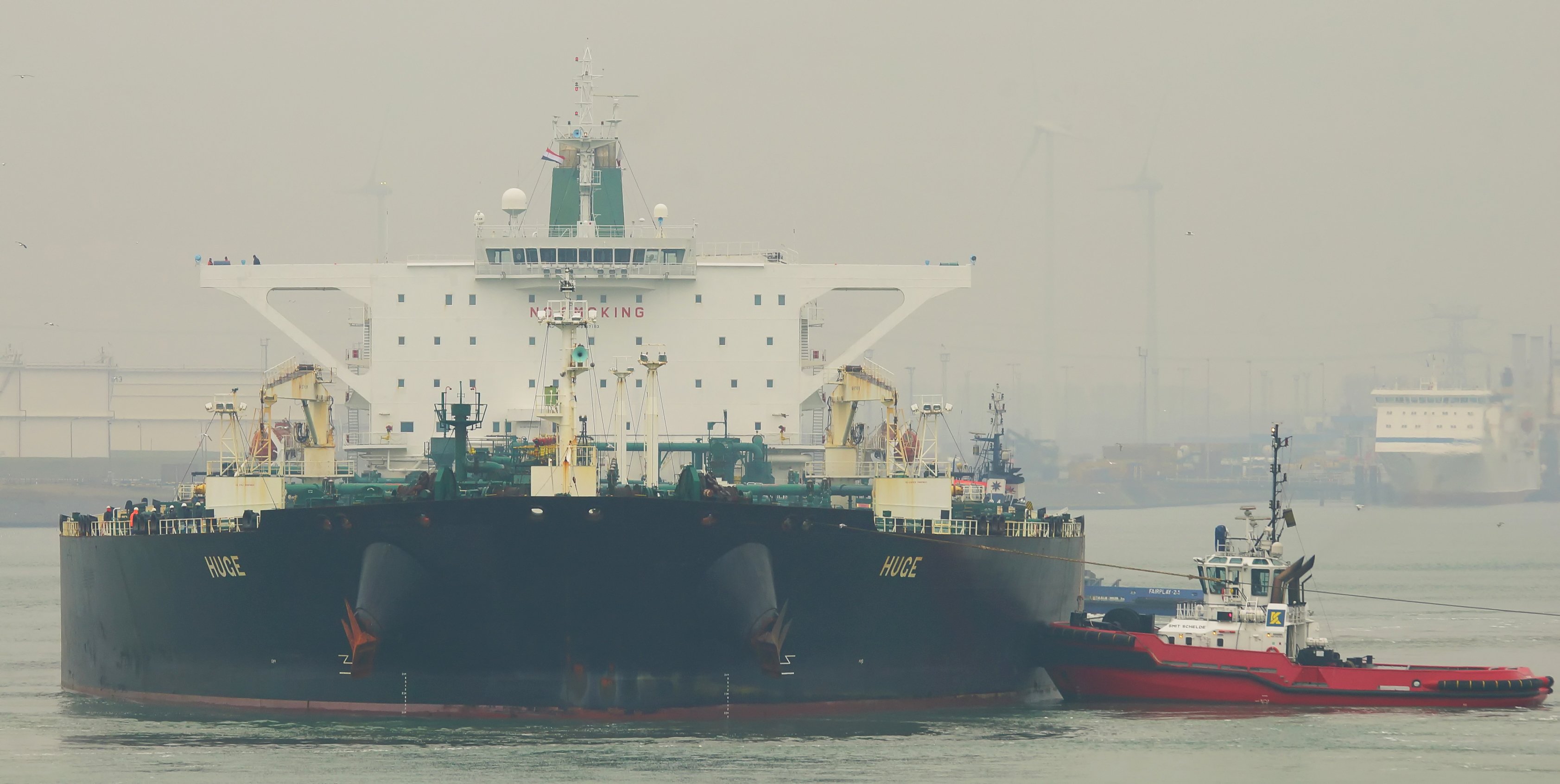 The Iranian supertanker Huge in port with a tug alongside