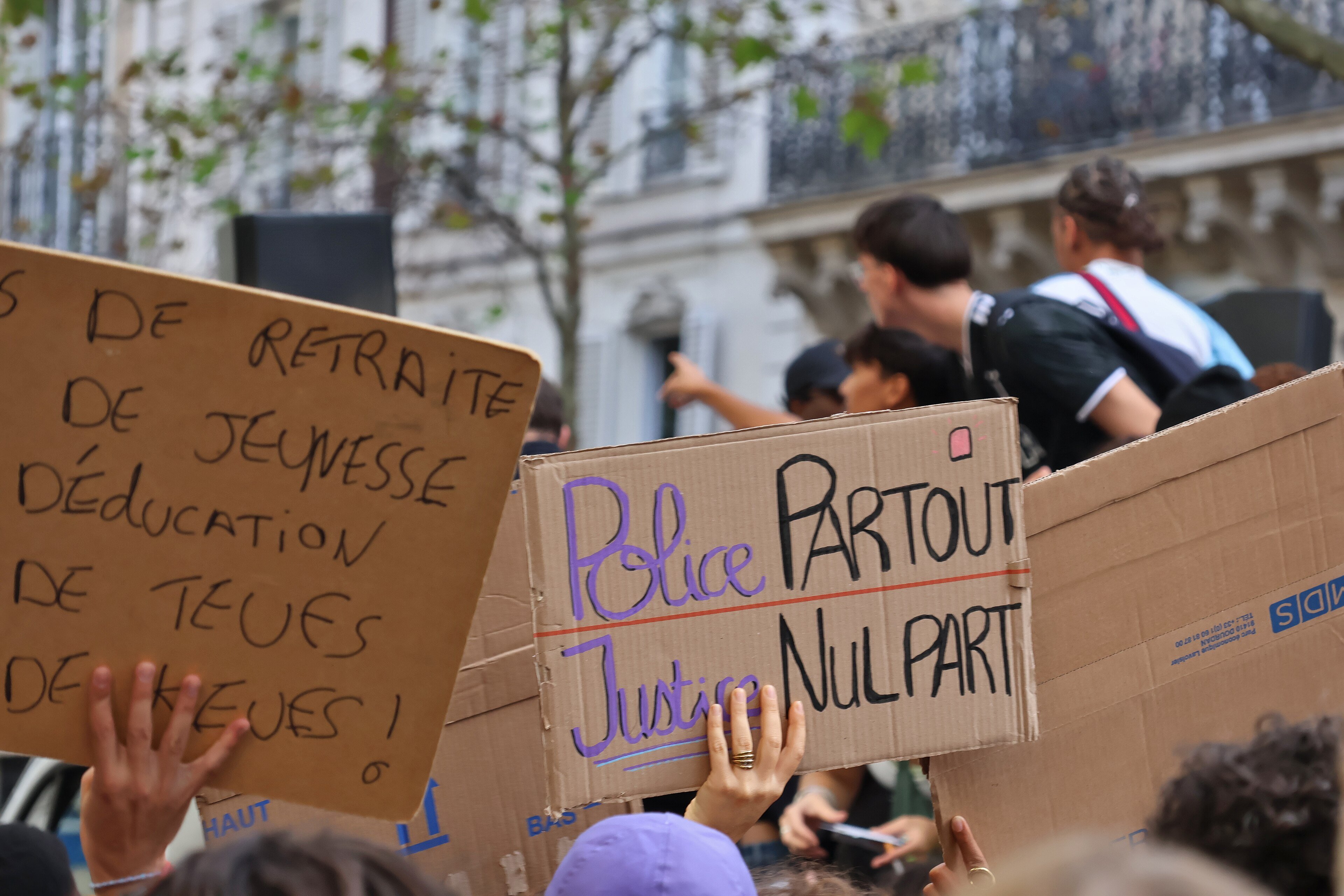 Protest signs held up in a crowd in Paris
