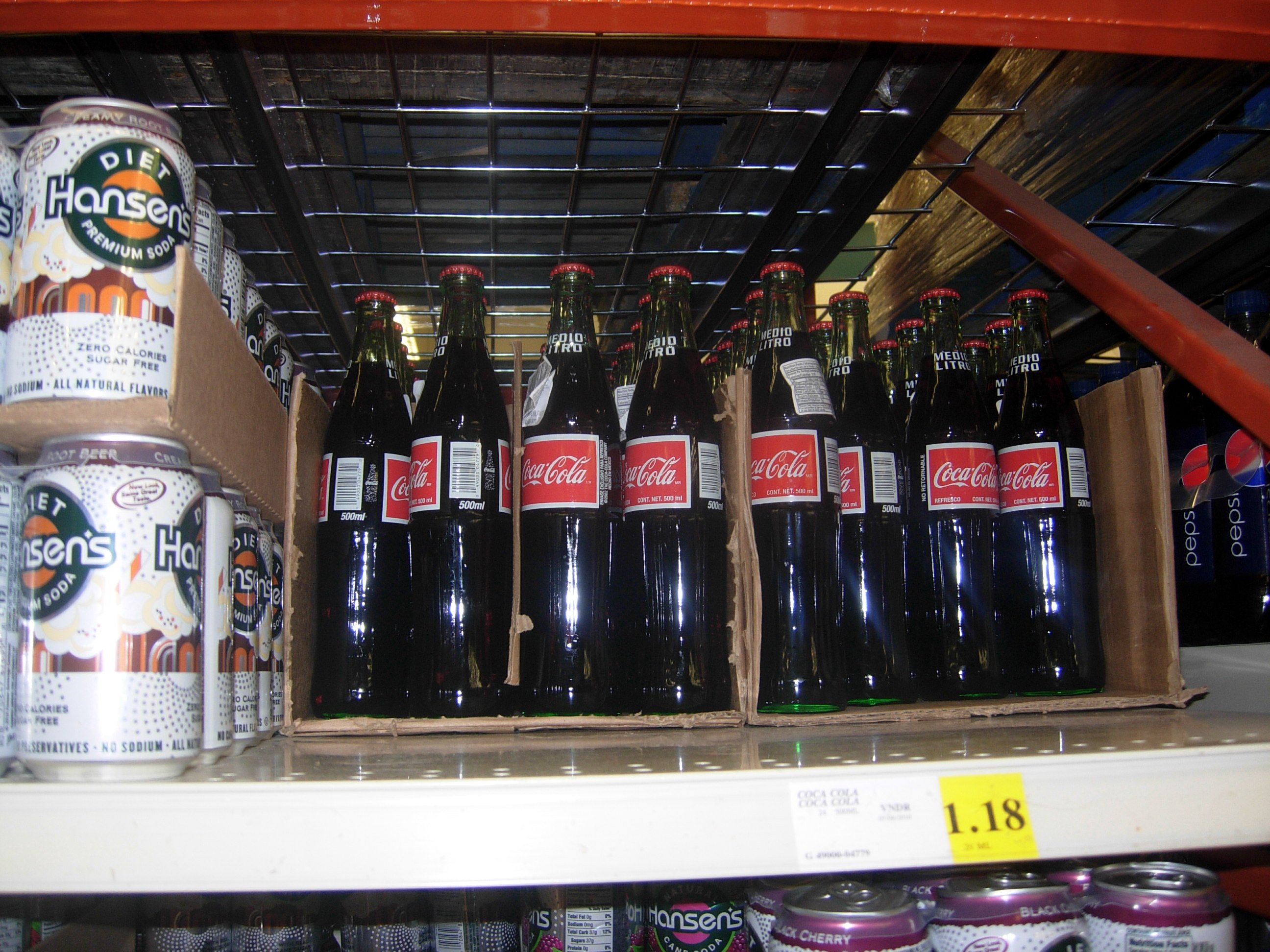 Coca-Cola bottles on a grocery store shelf