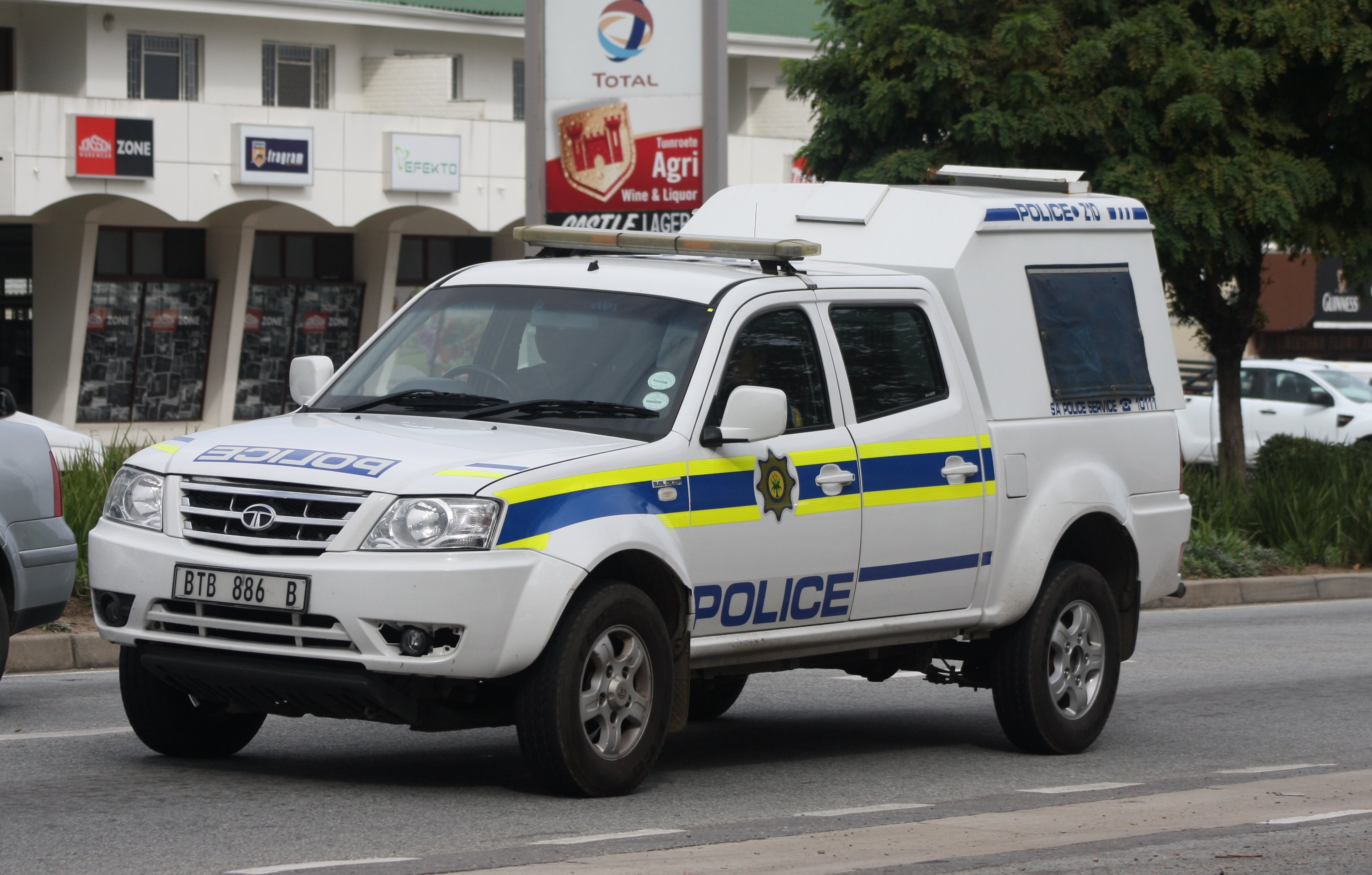 A white South African Police Service Tata Xenon patrol van parked on a street