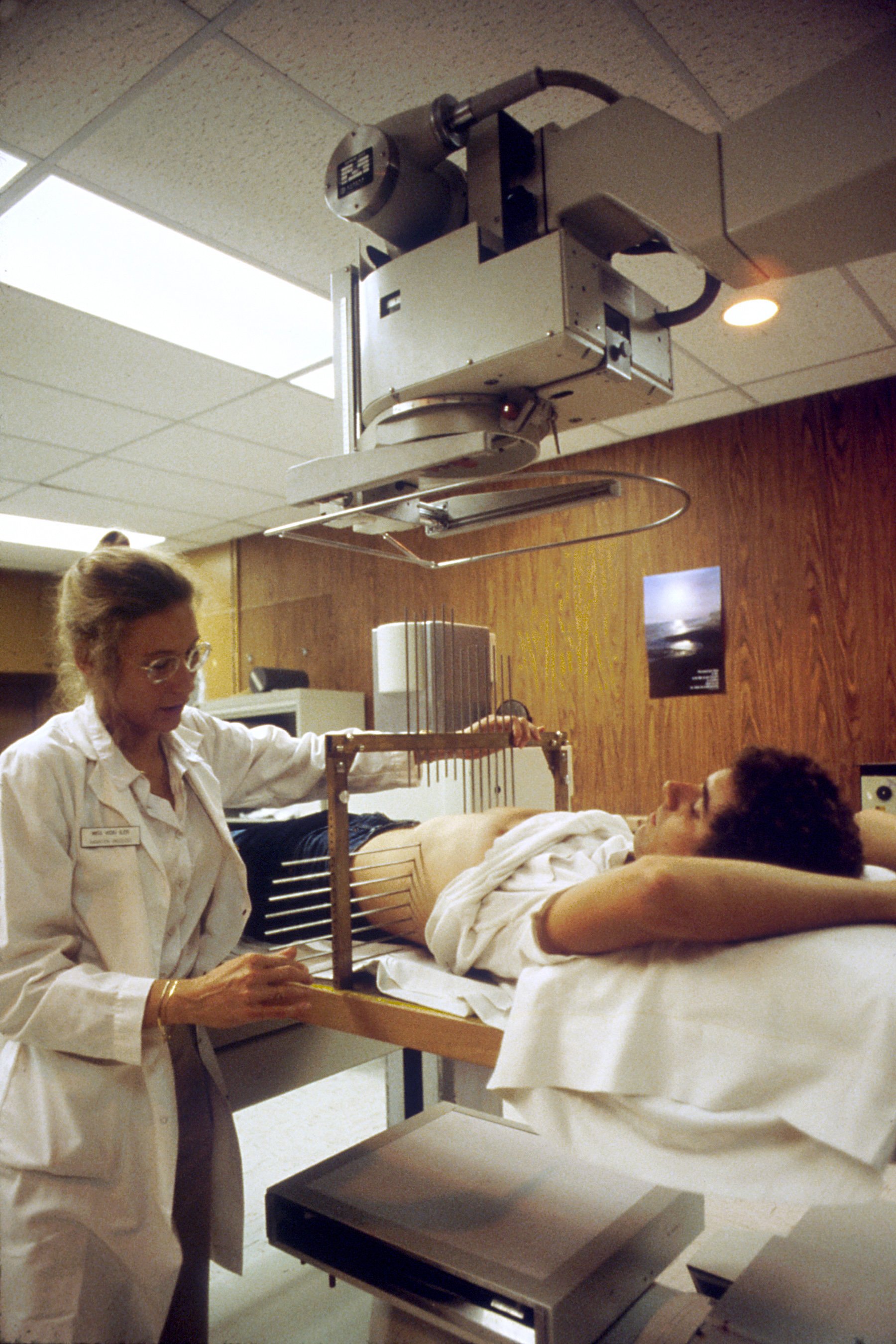 A radiation therapist preparing a patient for treatment