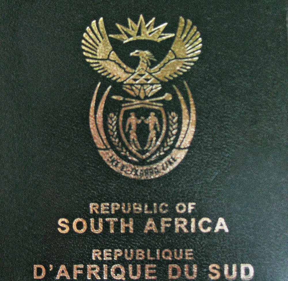 The green cover of a South African passport with the coat of arms in gold