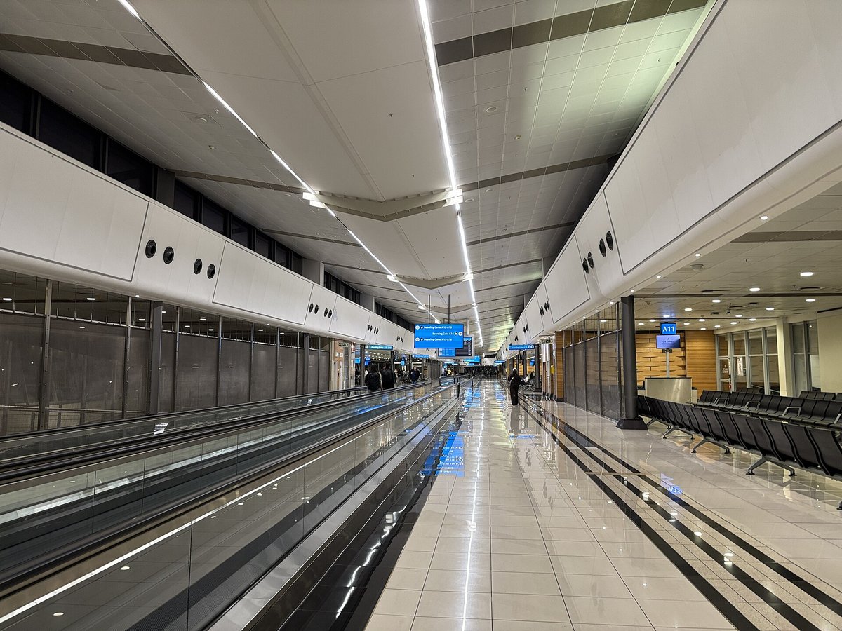 A long empty concourse with moving walkways at OR Tambo International Airport