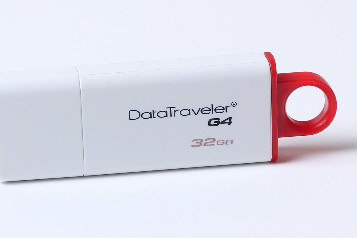 A white USB flash drive with a red loop