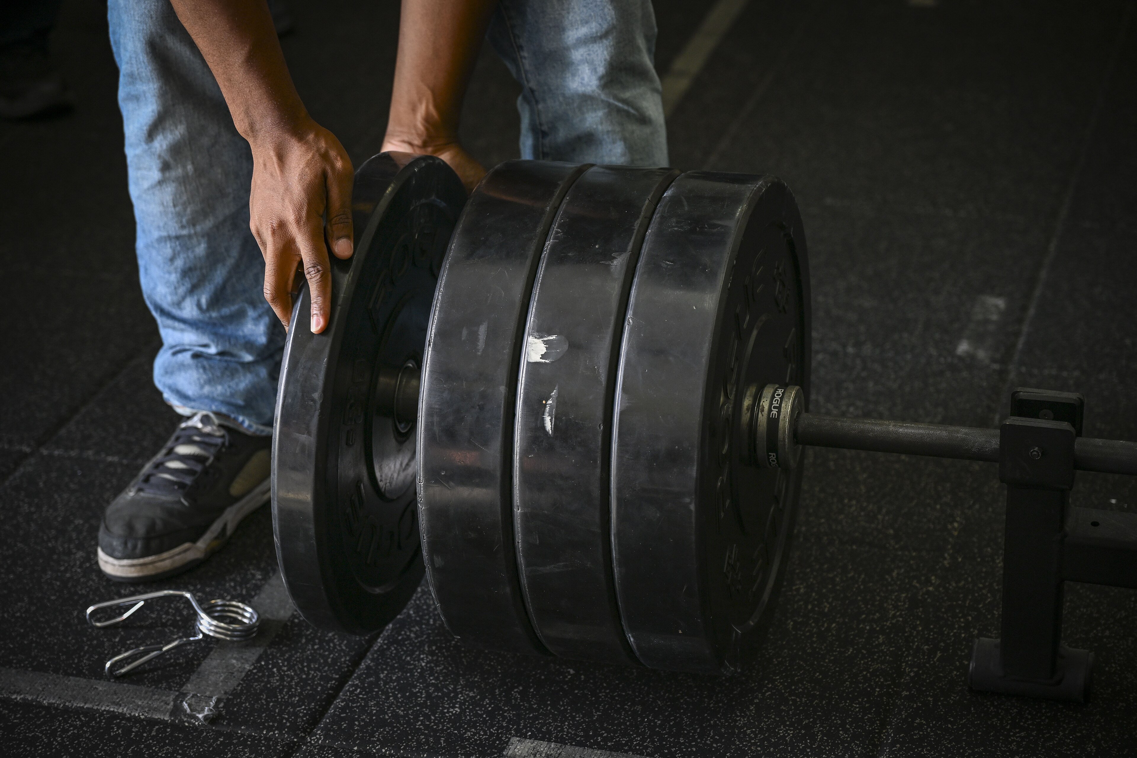 Weight plates being loaded onto a barbell at a powerlifting meet