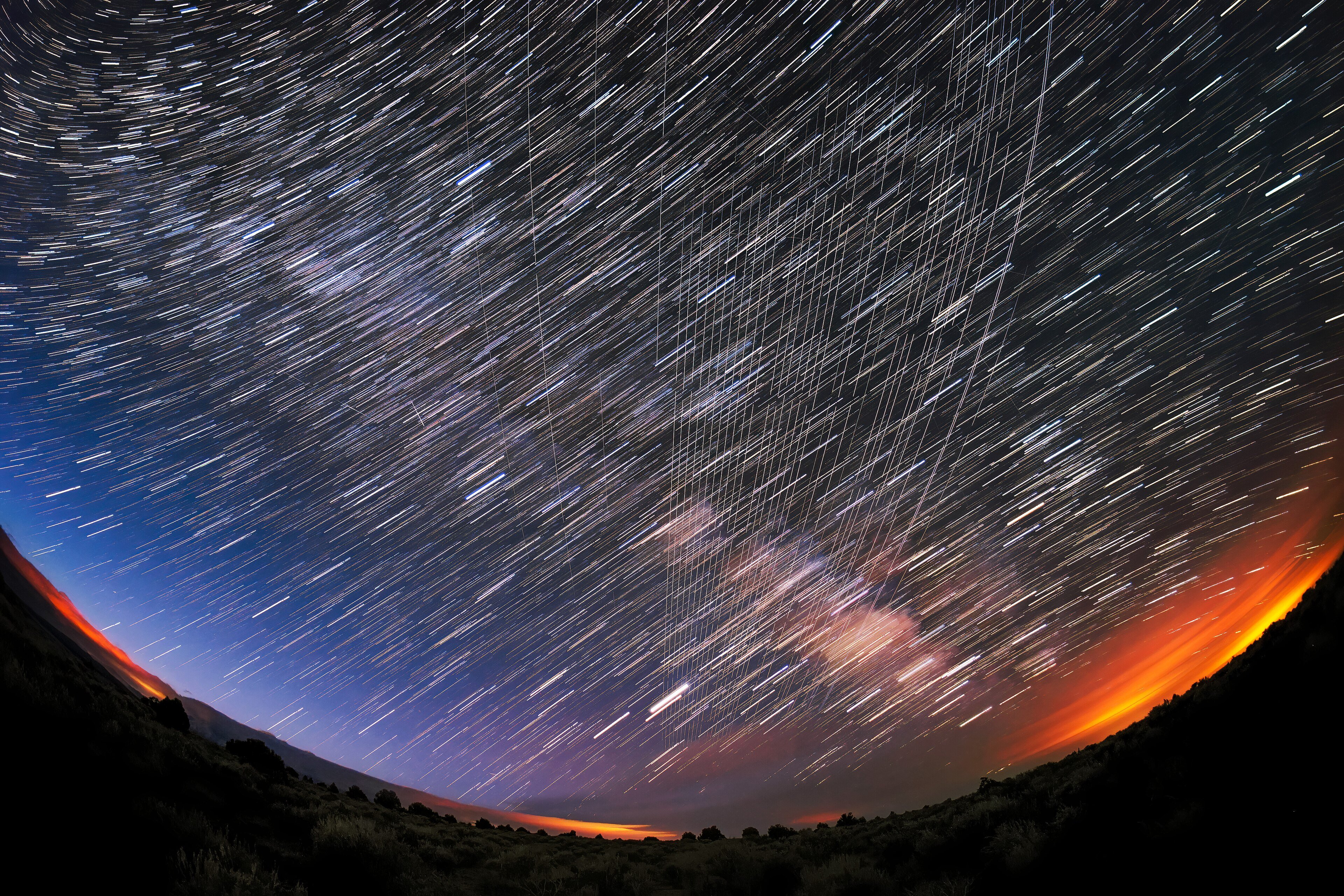 A long train of Starlink satellites crossing the night sky over Carson National Forest in New Mexico