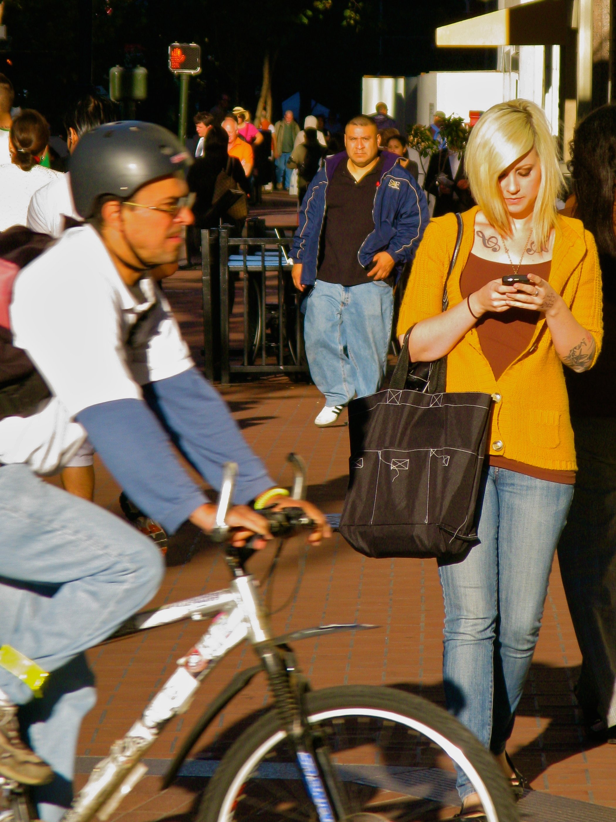 A woman texting on her phone on a street corner in San Francisco