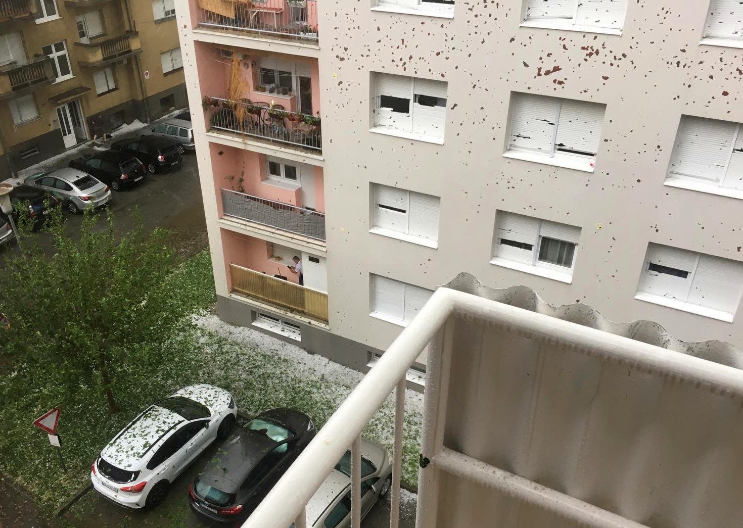 Hail damage to a roof and cars after a severe storm