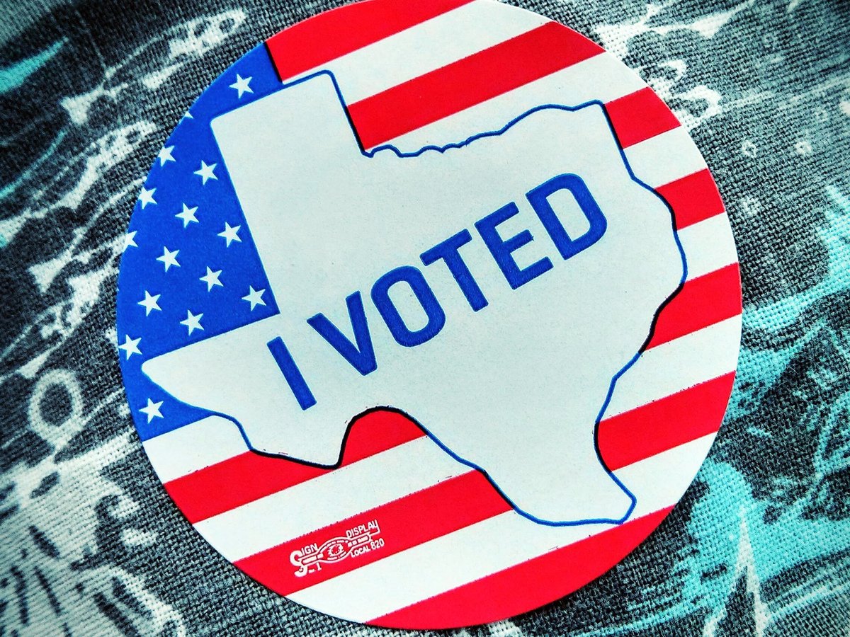 A round I Voted sticker shaped like the state of Texas over a US flag