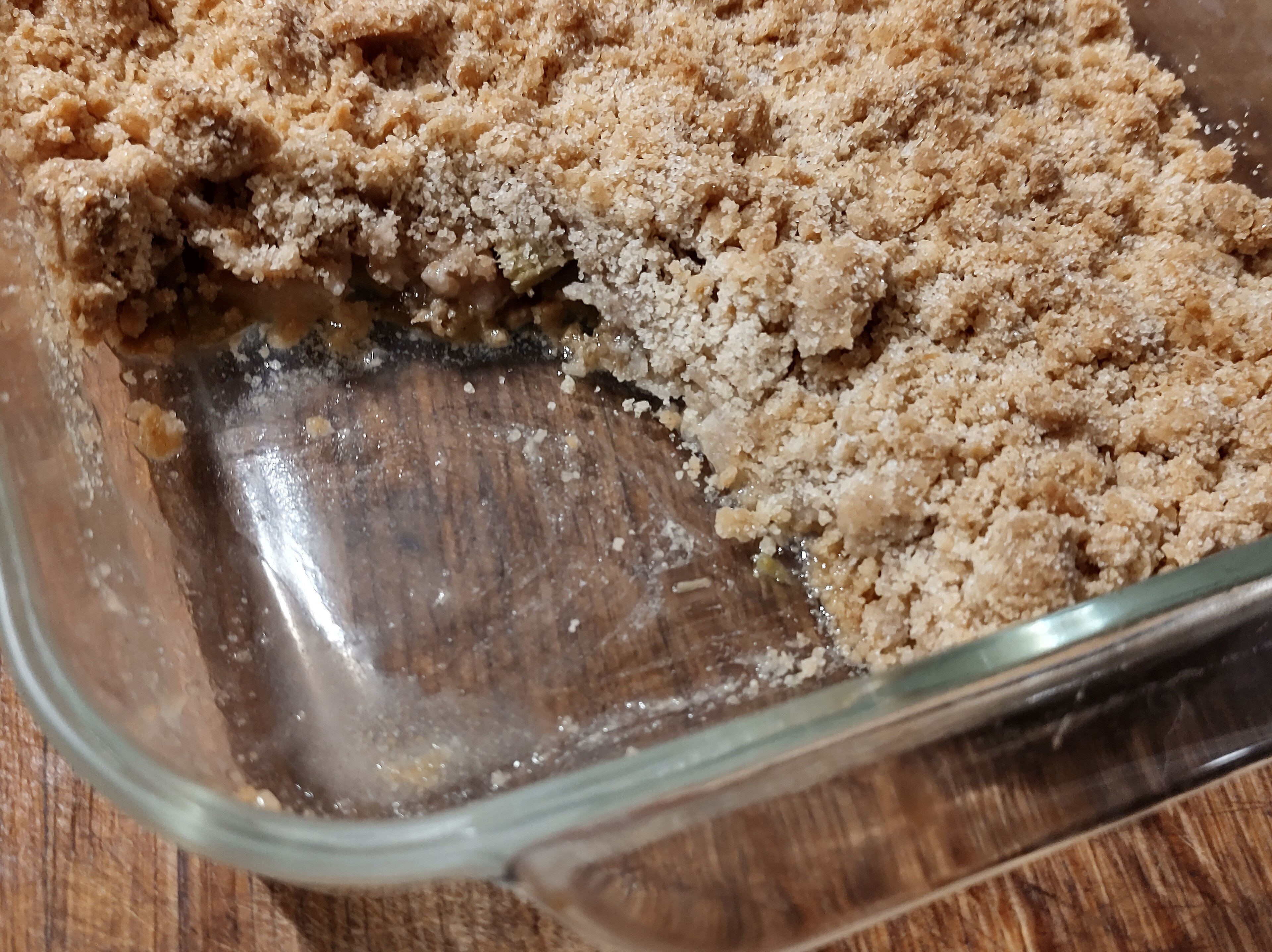 An apple crumble in a baking dish with a golden crumb topping