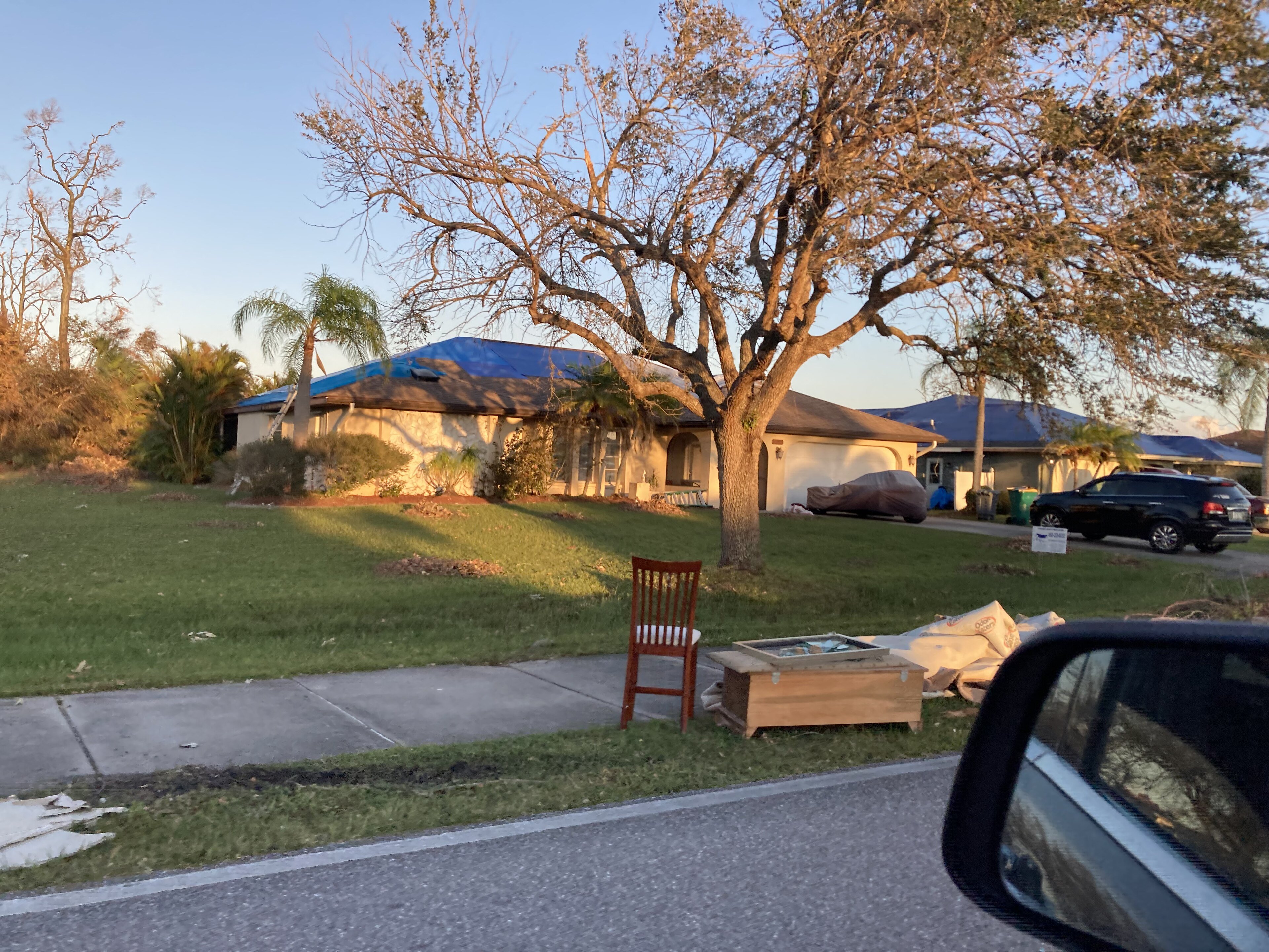 A Florida home with storm damage covered by a tarp after Hurricane Ian